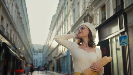 Elegant young woman with baguettes on the street