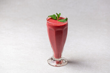Glass of fresh berry smoothie with mint on white background