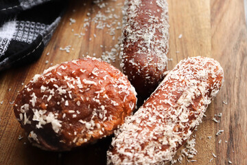 Koesisters on a wooden board. Koesisters are traditional South African snacks made from dough, syrup, coconut and mixed spices. Doughnuts deep fried snack