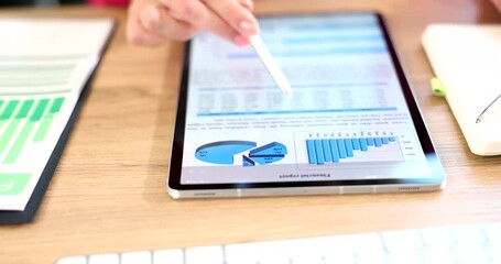 Business man analyzing financial statistics displayed on tablet screen