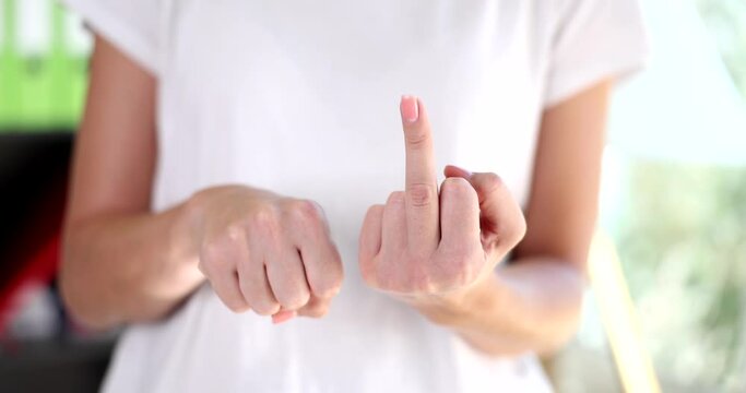 Woman slowly raises middle finger as sign of resentment and contempt hand gesture