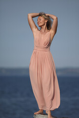 Fototapeta na wymiar young woman by the sea in a dress