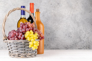 Fototapeta premium Ripe grape in basket and wine bottles