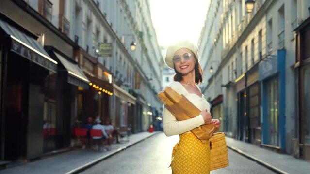 A young girl in a yellow skirt with baguettes walking from a French bakery