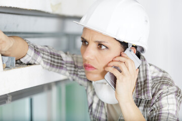 concerned female builder using smartphone