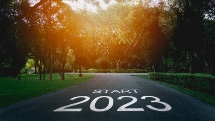 Happy new year 2023,2023 symbolizes the start of the new year. The letter start new year 2023 on the road in the nature garden park have tree environment ecology or greenery wallpaper concept. - obrazy, fototapety, plakaty