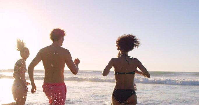 Friends, water and summer vacation on the beach for travel, freedom or holiday together in the outdoors. Happy joyful group of people enjoying playful time in the sun for friendship in the ocean - Powered by Adobe