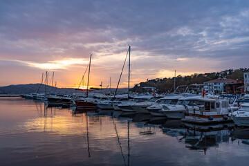 Sailboats at Tarabya yacht marina in Istanbul. Reflection of yachts and hotel. Blue sky and natural white clouds.	