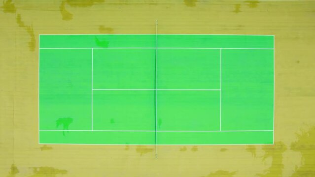 Drone footage from a bird's eye view of a modern and colorful tennis court. High resolution video. 4K.