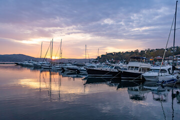 Sailboats at Tarabya yacht marina in Istanbul. Reflection of yachts and hotel. Blue sky and natural white clouds.	