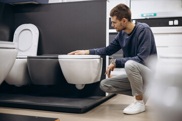 Man choosing home toilet in store