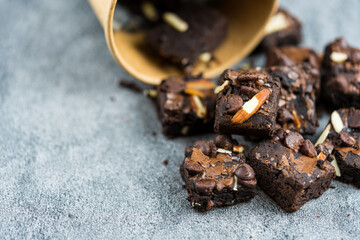 Dark chocolate butter brownies topping with slice almonds and chocolate chips. Close up