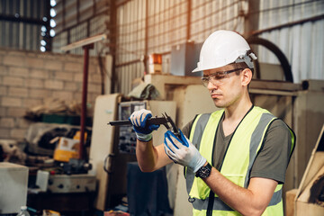 Industrial engineer wearing a white helmet working in industrial factory. 