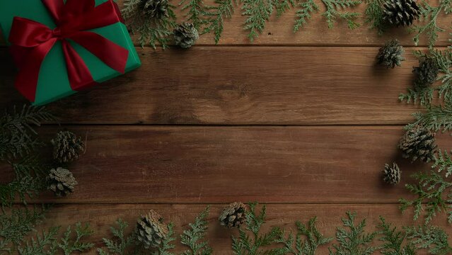 flat lay composition of christmas gifts and pine leaves on vintage wood table, top view