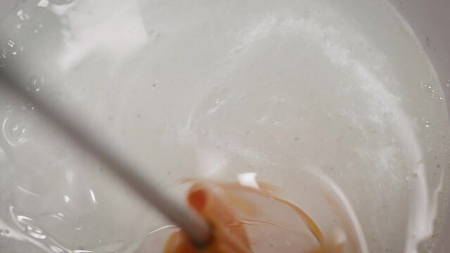 The process of preparing a multi-component epoxy resin. A professional kneads the resin with a colored tint