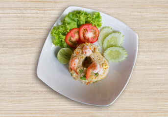 Fried rice with shrimp Thai food on a white dish on a wooden, top view