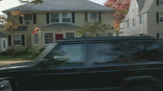 Driving past a historic neighborhood at fall time.  Halloween and Thanksgiving vibes. POV through window of car, which is easily cropped out if needed.