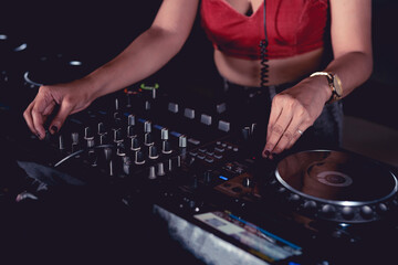 An anonymous female DJ adjusting the master gain on the mixer.