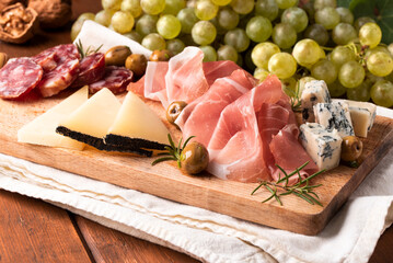 Tagliere con prodotti tipici italiani: prosciutto crudo, pecorino romano, salame,  gorgonzola e...