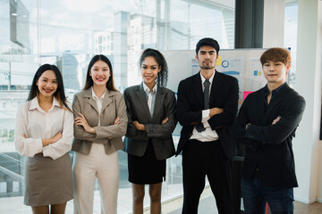 Group of business people standing in modern office looking at camera.