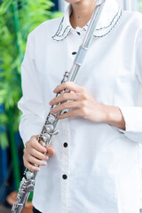 Flute :  A closeup of hands of a musician playing the flute, detail shot, classical music, wind instrument performance player up close abstract..