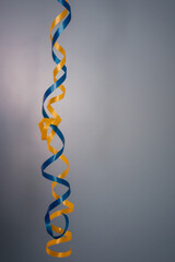 yellow and blue twisted ribbon on a gray background. 