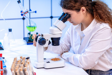 food quality control laboratory young woman inspecting linseeds before pressing organic oil