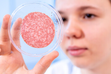 meat sausage quality control in the food inspection laboratory young woman examines the slice