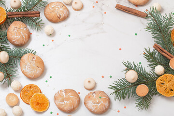Obraz na płótnie Canvas candies and cookies with christmas tree branches on white marble background