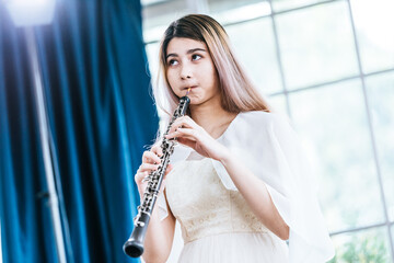 Portrait of Young Female Musician Playing Clarinet. Rehearsal before performing on stage.
