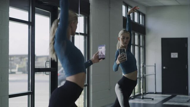 Dancer performing and posing for social media cell phone selfies near mirror / Lehi, Utah, United States