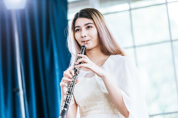 Portrait of Young Female Musician Playing Clarinet. Rehearsal before performing on stage.
