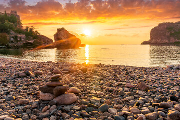 morning or evening landscape with nice beach , a sunrise or sunset in sea with amazing isle with rocks and beautiful clouds on background