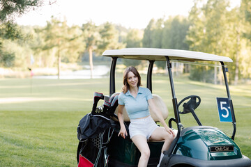 Young woman in golf car outdoors. High quality photo