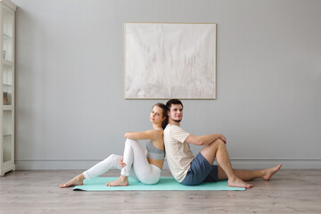 Couple of people sit on the carpet in the studio and relax after yoga class. High quality photo