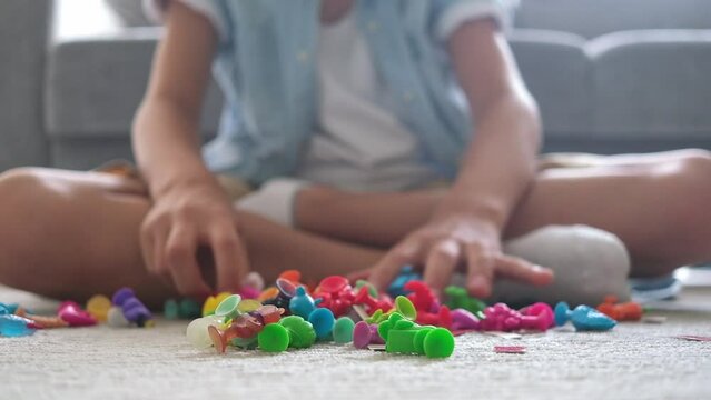 Little toddler boy playing with colorful plastic toys at home living room on carpet building creative game, imagination.