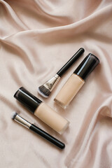 Cosmetics and brushes are on the table. Foundation and brushes for it. High quality photo