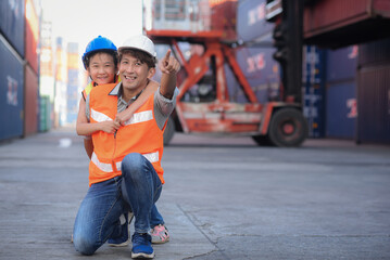 Asian father who owns an import-export, warehouse business. looking and pointing at containers,...