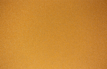 Golden wall with abstract spots as a background. Beautiful golden texture with patterns, decorative plaster. Modern bright wall painting in trendy shades, unusual spotted yellow and gold surface.