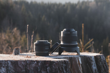 Photographic lenses placed on a stump. Technology for capturing moments, landscapes, people