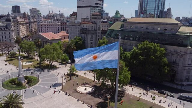 Aerial push-out of flag of Argentina at Plazo de Mayo in Buenos Aires