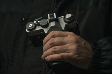 man holding Retro film photo camera isolated on black background soviet