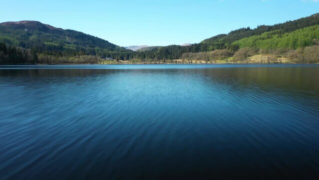 4K Aerial Footage of Loch Chon flying along water pull up to reveal rugged scenery in Trossachs National Park Scottish Highlands, Scotland, United Kingdom