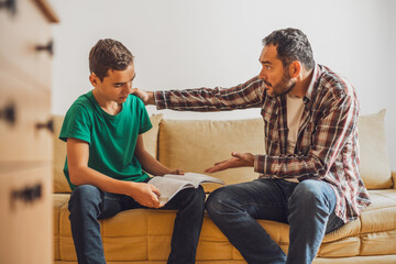 Father is helping his son with learning. Boy is having problem with homework.
