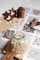 Homemade milk chocolate star shaped chocolate lolly on a stick.