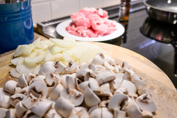 a wooden board with chopped vegetables and meat ready for cooking