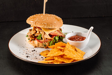 Tasty fresh burger with shopped meat and chips on wooden background