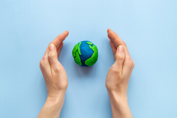 Modeling clay world in hands. Earth Day concept