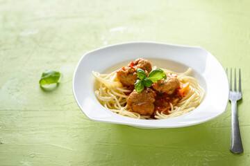 homemade pasta with tomato sauce and cooked meatballs