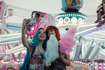 Girls taking a selfie at the fair - obrazy, fototapety, plakaty